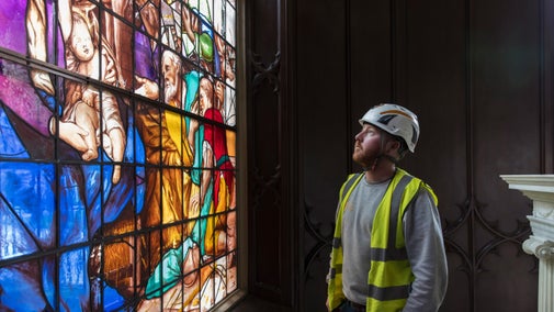 Specialist from Holy Well Glass looks at newly conserved stained glass at The Vyne, Hampshire